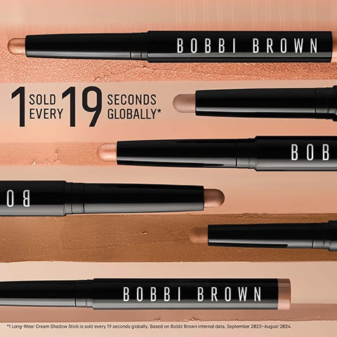 Image 1 - Image shows multiple Bobbi Brown Long-Wear Cream Shadow Sticks arranged on a soft, light-colored background with the text 1 SOLD EVERY 19 SECONDS GLOBALLY* prominently displayed.
Image 2 - An image of a Bobbi Brown cosmetic stick placed against a background of various neutral shades, featuring text that highlights its features: 24HR Longwear, 24HR Crease and Smudge Proof Wear, Creamy, Rich, Blendable Colour, and Water and Sweat Proof.
Image 3 - Image shows three makeup products arranged in a row, with A FLAWLESS ROUTINE at the top and labeled steps beneath each product; from left to right: a brown Long-Wear Cream Shadow Stick, a black Long-Wear Cream Liner Stick, and a white Smokey Eye Mascara.