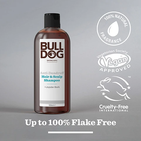 Image 2 - A bottle of Bulldog Anti-Dandruff Hair & Scalp Shampoo with a dark brown liquid, labeled with 100% NATURAL FRAGRANCE, Vegetarian Society Vegan APPROVED, and Cruelty-Free International, along with the text Up to 100% Flake Free.
Image 3 - Close-up of various pieces of jujube bark on a light background with the text 100% Natural Fragrances and Jujube Bark.
Image 4 - A hand is holding a bottle of Bull Dog Anti-Dandruff Shampoo, with the bottles label visible, and a drop of shampoo being dispensed onto an open palm; the text at the bottom reads Up to 100% Flake Free.
Image 5 - A person holds a brown bottle of Bulldog Skincare Anti-Dandruff Hair & Scalp Shampoo, with visible text stating 100% Recycled PCR Plastic Bottle and Recycled Plastic Bottle.
Image 6 - Two brown bottles of Bulldog skincare products are displayed on a tiled surface; the left bottle is labeled Peppermint & Eucalyptus Shower Gel, and the right bottle is labeled Anti-Dandruff Hair & Scalp Shampoo, and there is text at the bottom that reads Start the Day Right.
