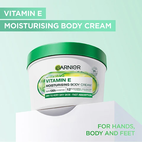 Image 1 - A tub of Garnier Vitamin E Moisturising Body Cream on white blocks with text Vitamin E Moisturising Body Cream For Hands Body And Feet and on the label Garnier Vitamin E Moisturising Body Cream Natural 96% Origin Ingredients Up to 100h Hydration 12% Glycerin + Shea Butter + Vitamin E + Avocado Dry To Very Dry Skin - Fast Absorption. Image 2 - A split image shows dry skin on an arm labeled BEFORE and hydrated skin on the same arm labeled AFTER, with overlay text HYDRATES UP TO 10 CELL LAYERS DEEP* and below the AFTER label the text *up to 10 cell layers of the stratum corneum. Image 3 - A clear capsule containing avocado and bubbles is shown alongside text listing ingredients: INGREDIENTS:, GLYCERIN, AVOCADO, SHEA BUTTER, VITAMIN E. Image 4 - A tub of Garnier Vitamin E Moisturising Body Cream is shown surrounded by cream swirls, with the text INTENSE MOISTURE BOOST, GARNIER, VITAMIN E MOISTURISING BODY CREAM, NATURAL 96% ORIGIN INGREDIENTS, Up to 100h HYDRATION*, 12% GLYCERIN + SHEA BUTTER + VITAMIN E + AVOCADO, DRY TO VERY DRY SKIN - FAST ABSORPTION visible. Image 5 - Hands hold a tub of Garnier Vitamin E Moisturising Body Cream with product on one hand; text includes FORMULATED FOR EXTRA DRY SKIN, FAST ABSORPTION, NOURISHING BODY CREAM, Garnier, VITAMIN E MOISTURISING BODY CREAM, Up to 100h HYDRATION*, 12% GLYCERIN + SHEA BUTTER + VITAMIN E + AVOCADO, DRY TO VERY DRY SKIN - FAST ABSORPTION, Natural 96% Origin Ingredients. Image 6 - The image shows an older Garnier Vitamin E Moisturising Body Cream tub and a newer Garnier Body Superfood Avocado + Omega 6 48h Nourishing Cream tub with an arrow pointing to the new one, displaying the text NEW PACK. SAME GREAT RESULTS, Garnier Vitamin E MOISTURISING BODY CREAM Up to 100h HYDRATION* 12% GLYCERIN + SHEA BUTTER + VITAMIN E + AVOCADO DRY TO VERY DRY SKIN - FAST ABSORPTION NATURAL 96% ORIGIN INGREDIENTS, and Garnier Body SUPERFOOD Avocado + OMEGA 6 48h NOURISHING CREAM HYDRATE SKIN UP TO 10 LAYERS DEEP Dry Skin Fast-absorption Cruelty Free INTERNATIONAL VEGAN FORMULA 380ml e NATURAL 97% ORIGIN.